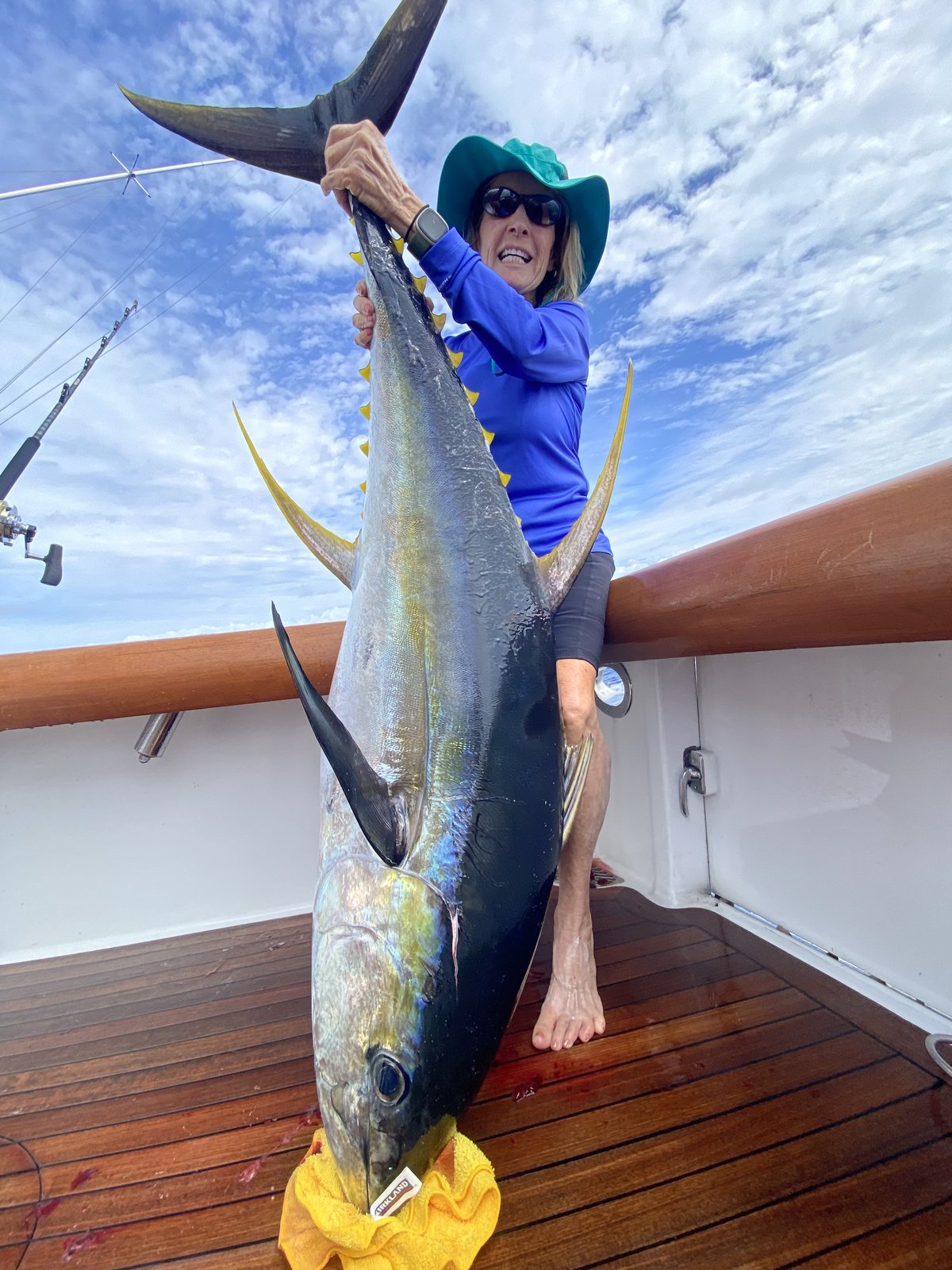Angler with a yellowfin ahi at the boat rail
